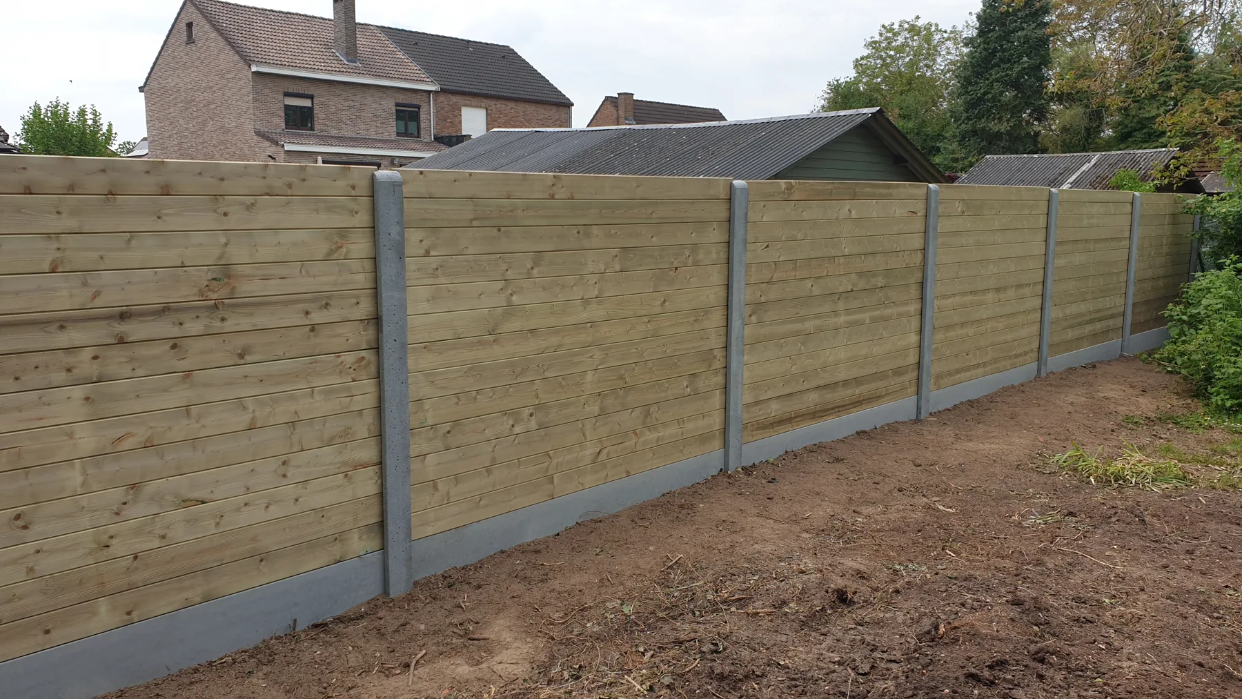 Houten panelen tussen betonnen palen