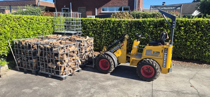 Compacte lader met een korf brandhout
